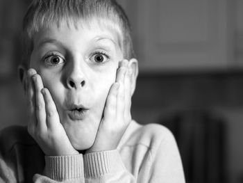 Close-up portrait of shocked boy at home