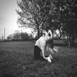 Young woman dancing on grassy field in park