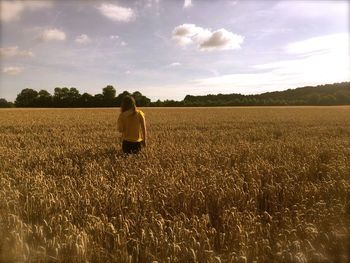 Rear view of people walking on field