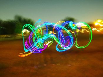 Close-up of illuminated light painting against sky at night