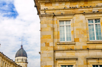 Low angle view of birds perching on government building at bolivar square