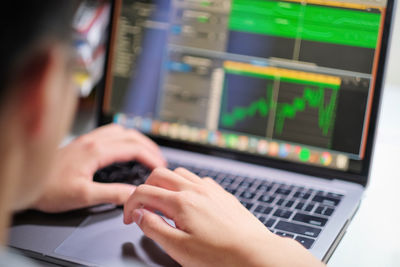 Close-up of man using laptop on table