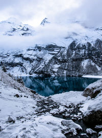 Lake amidst snowcapped mountains against sky