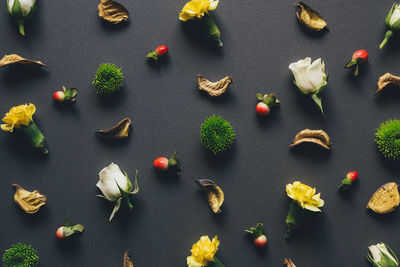 High angle view of flowers with fruits and leaf arranged on table