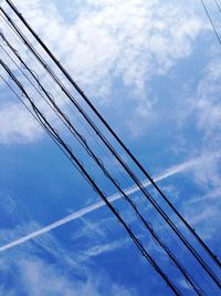 Low angle view of electricity pylon against cloudy sky