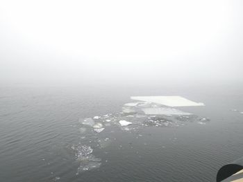 Close-up of snow on shore against sky