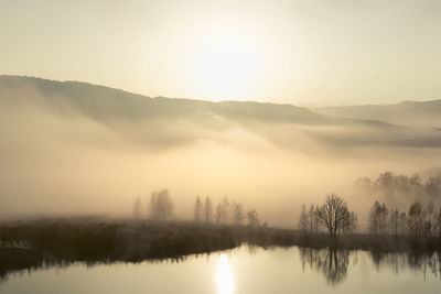 Scenic view of lake against sky during sunset