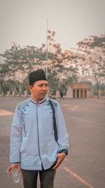 Young man looking away while standing outdoors