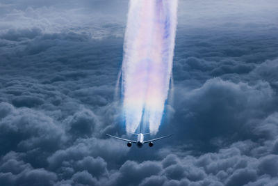 High angle view of airplane flying over cloudy sky