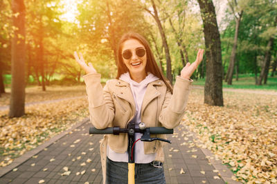 Portrait of young woman wearing sunglasses while standing in park