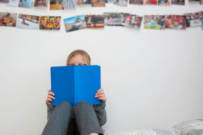 School age girl sitting in her bedroom and doing school homework.