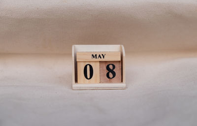 Close-up of information sign on table against wall