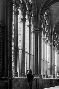 Rear view of women standing in cathedral corridor