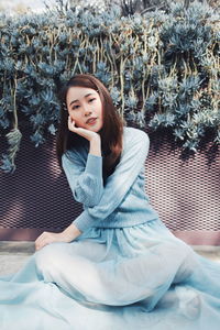 Portrait of smiling young woman sitting on bed