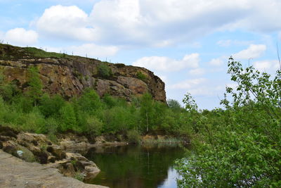 Scenic view of river against cloudy sky