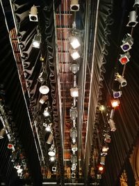 Low angle view of illuminated lights hanging on ceiling in building