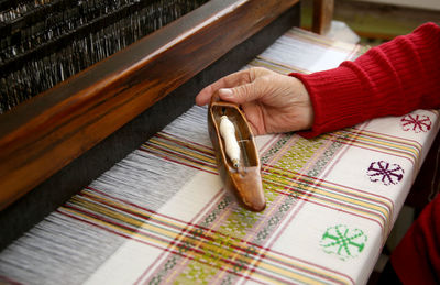 Cropped hand of person wooden thread