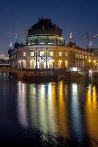 River in front of illuminated bode-museum at dusk