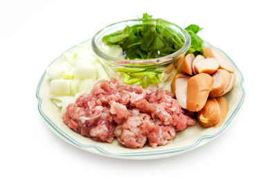 Close-up of food in plate against white background