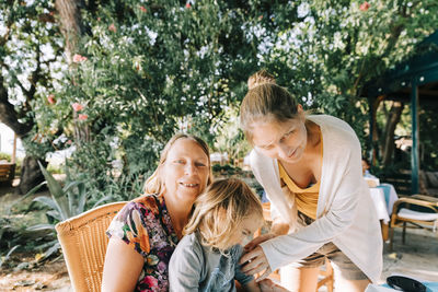 Happy friends sitting outdoors