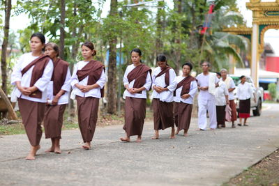 Group of people walking on footpath in city