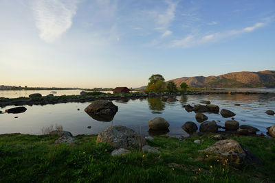 Scenic view of rocks by lake against sky