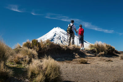 Rear view of hikers standing on mountain