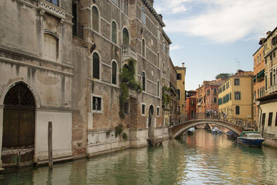 Venice landscape by boat, a tiny canal with old houses and a bridge