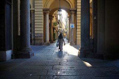 Rear view of woman walking on corridor of building