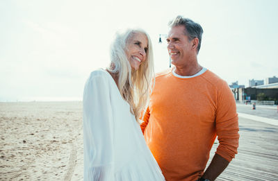 Smiling couple standing at beach