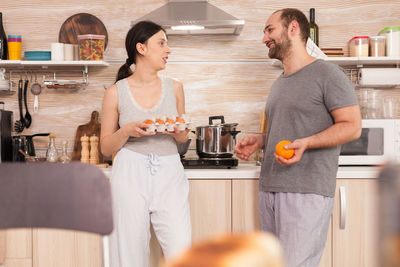 Young couple in front of two people at home