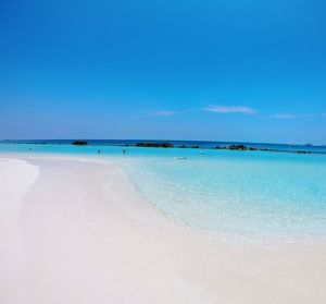 Scenic view of beach against blue sky