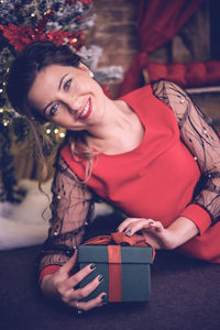 Portrait of young woman sitting on bed at home