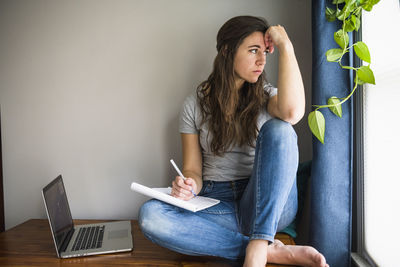 Lonely individual woman on her laptop working / studying at home