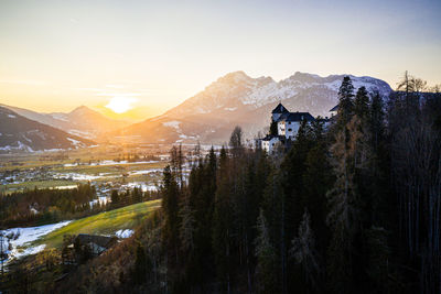 Scenic view of snowcapped mountains against sky during sunset with a castle in the voreground