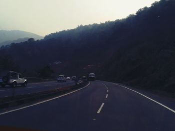 Road by mountain against sky