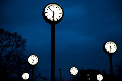 Low angle view of illuminated clock against sky