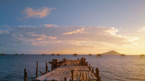 Pier over sea against sky during sunset