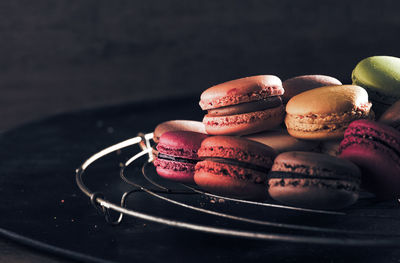 Colorful macaroons on table against black background