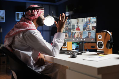 Rear view of woman using mobile phone in office