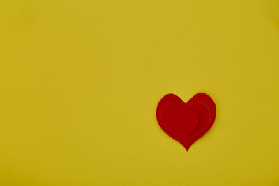 Close-up of heart shape against yellow background