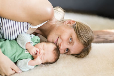 Portrait of mother lying with son on bed at home