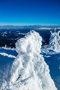 Aerial view of snowcapped mountains against clear blue sky