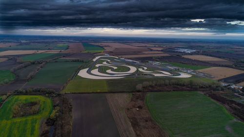 High angle view of road amidst field against sky