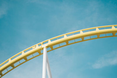Cropped image of amusement park ride against blue sky