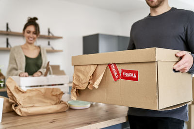 Portrait of smiling young man holding box