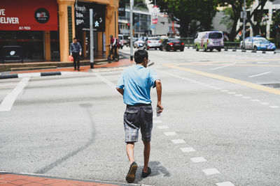 Rear view of people walking on city street