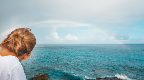 Woman looking at sea against sky