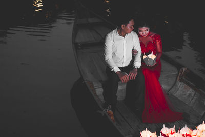 Couple holding hands in water at night