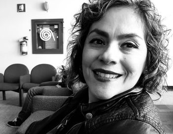 Portrait of smiling mid adult woman sitting in waiting room